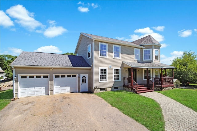 view of front facade featuring a porch, a garage, and a front lawn