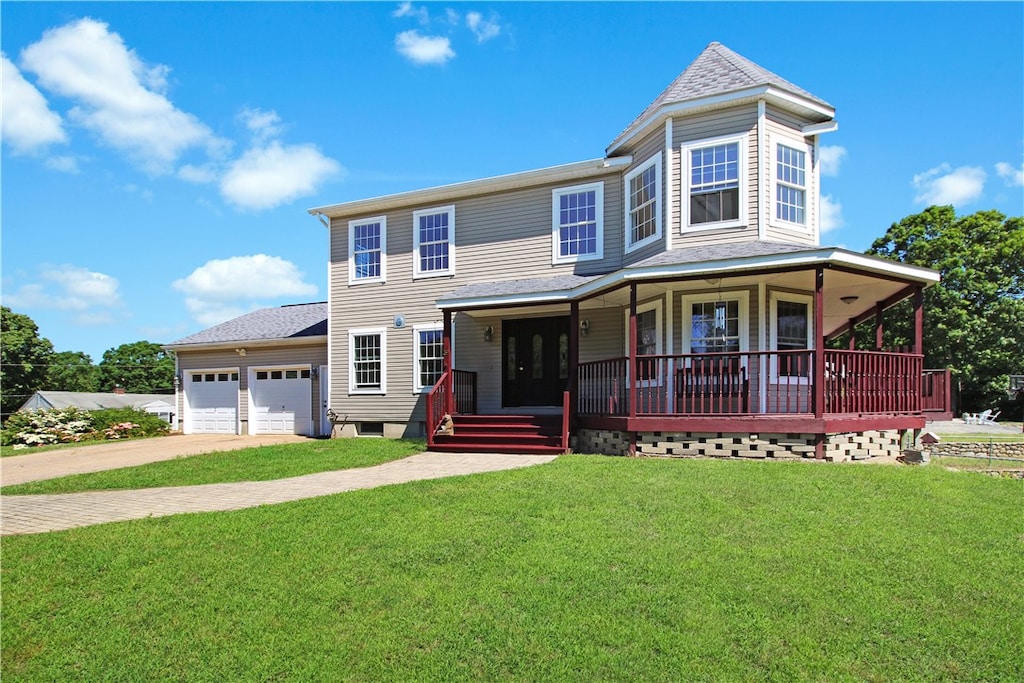 view of front of house featuring a porch, a garage, and a front lawn