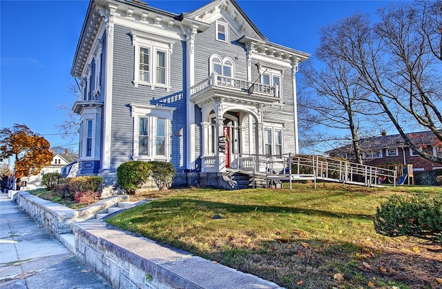 italianate home with a balcony and a front yard