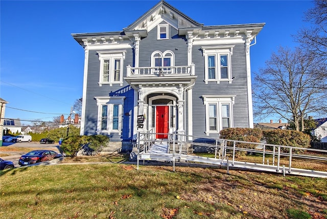 italianate home with a balcony and a front lawn