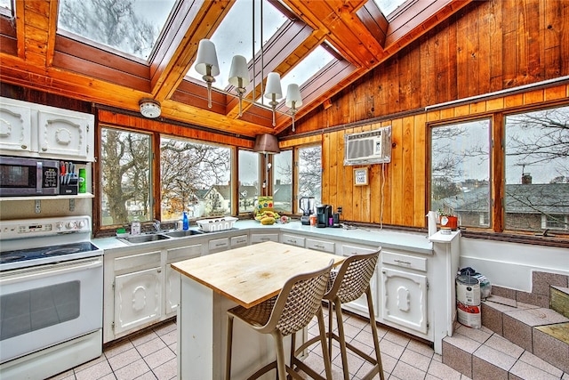 kitchen with a breakfast bar, white cabinetry, white electric range, and sink