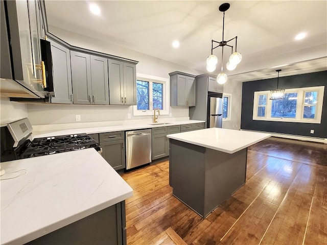 kitchen with a center island, stainless steel appliances, an inviting chandelier, and dark hardwood / wood-style floors