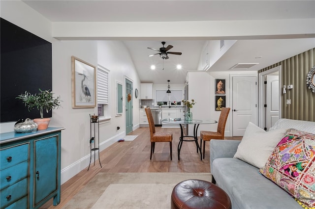 living room featuring light hardwood / wood-style flooring, vaulted ceiling, and ceiling fan