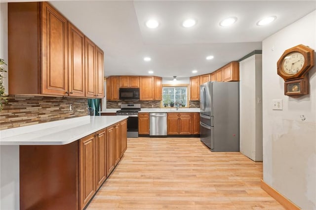 kitchen featuring sink, stainless steel appliances, tasteful backsplash, and light hardwood / wood-style flooring