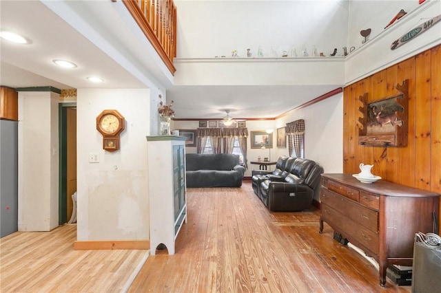 living room with light hardwood / wood-style floors, ceiling fan, and ornamental molding