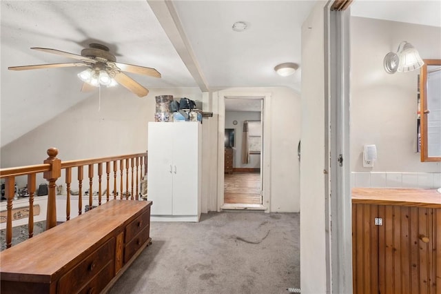 hallway with light colored carpet and vaulted ceiling