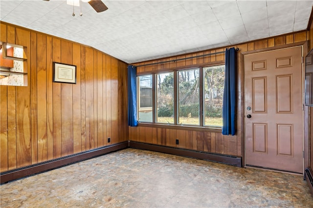 entryway with a baseboard radiator, ceiling fan, and wooden walls