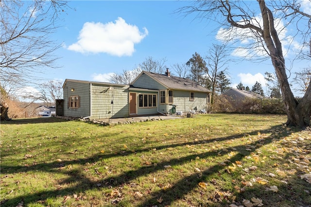 back of house featuring a lawn and a patio area