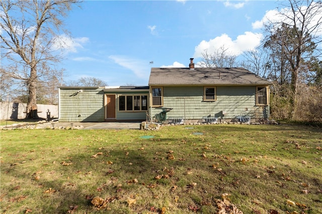 rear view of property with a patio and a lawn