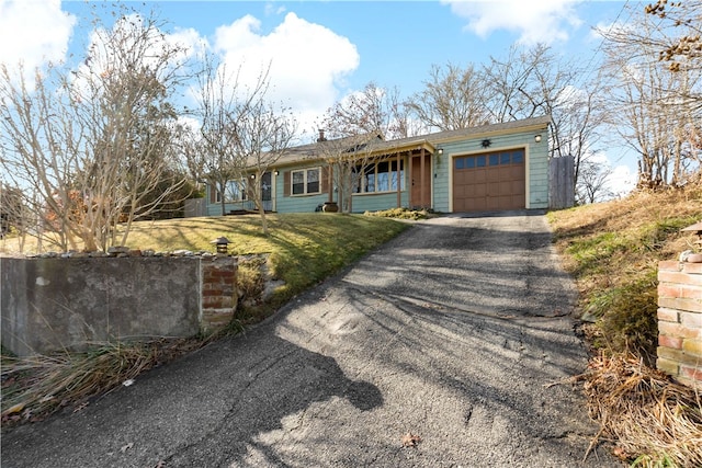 single story home featuring a garage and a front lawn