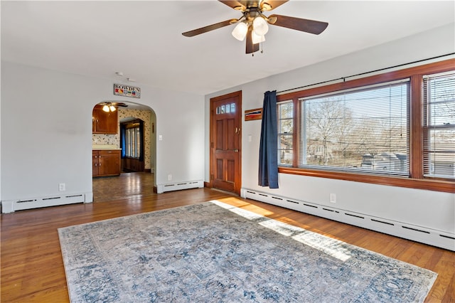 entrance foyer featuring dark hardwood / wood-style flooring, ceiling fan, and a baseboard heating unit