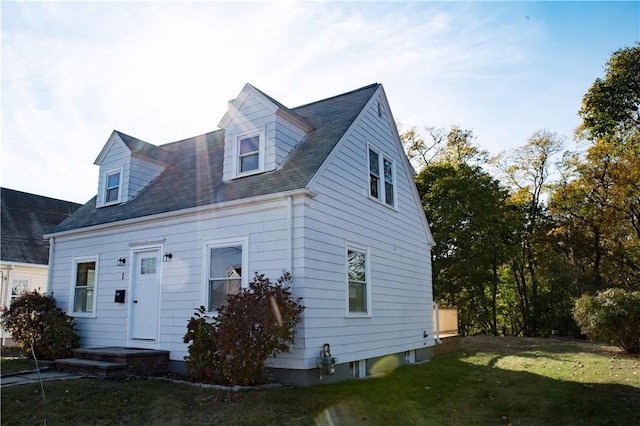 cape cod home featuring a front yard