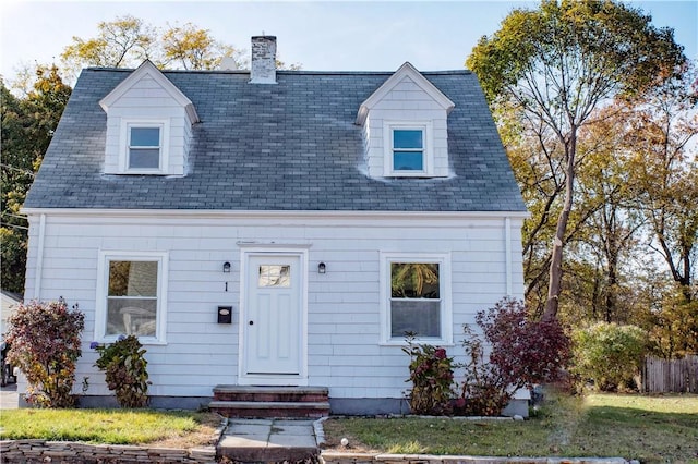 cape cod house with a front yard