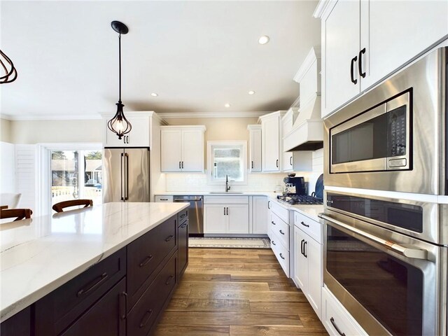 kitchen with white cabinets, decorative light fixtures, a healthy amount of sunlight, and stainless steel appliances