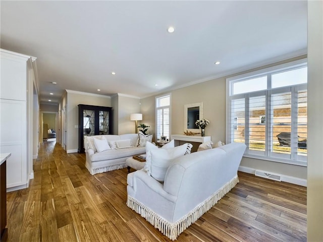 living room featuring hardwood / wood-style flooring, ornamental molding, and a wealth of natural light