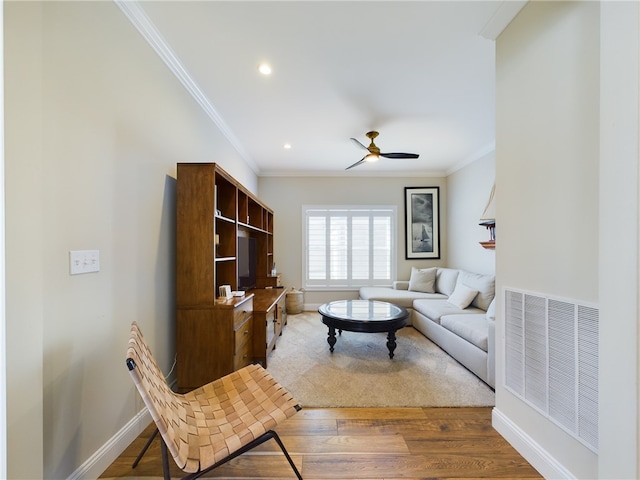 living room with hardwood / wood-style floors, ceiling fan, and crown molding