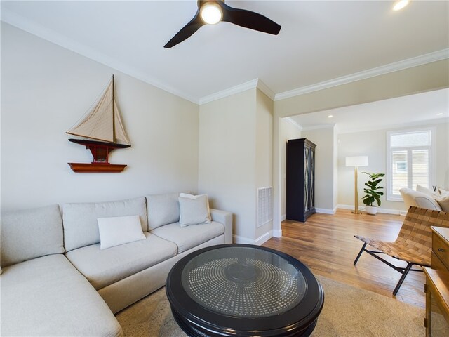 living room with hardwood / wood-style flooring, ceiling fan, and crown molding