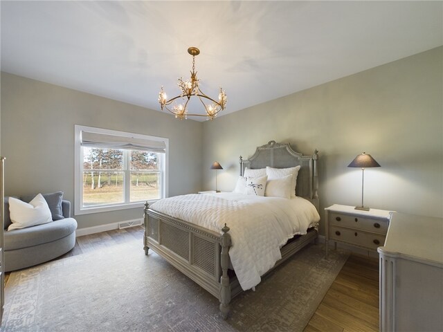 bedroom with an inviting chandelier and hardwood / wood-style flooring