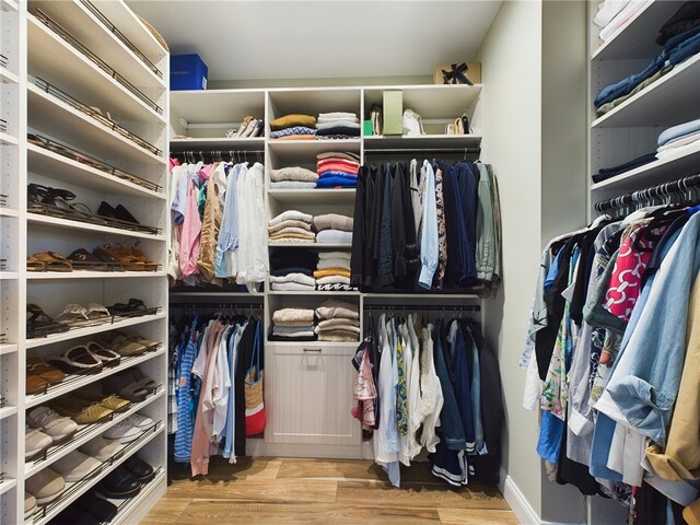 walk in closet with light hardwood / wood-style floors