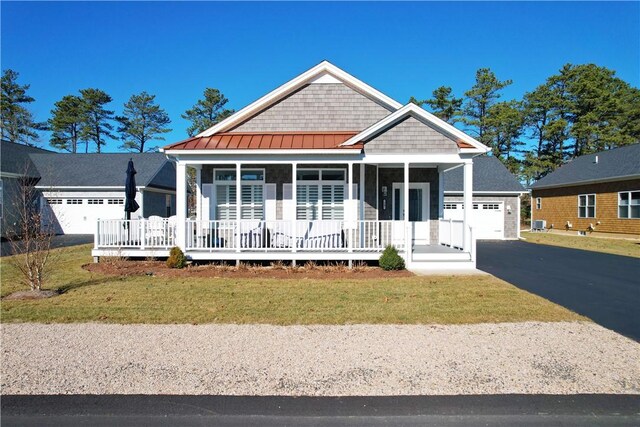 view of front of property featuring a front yard, a porch, and a garage