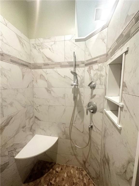 bathroom featuring tile walls and tiled shower