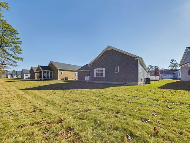 back of house featuring a yard and central AC