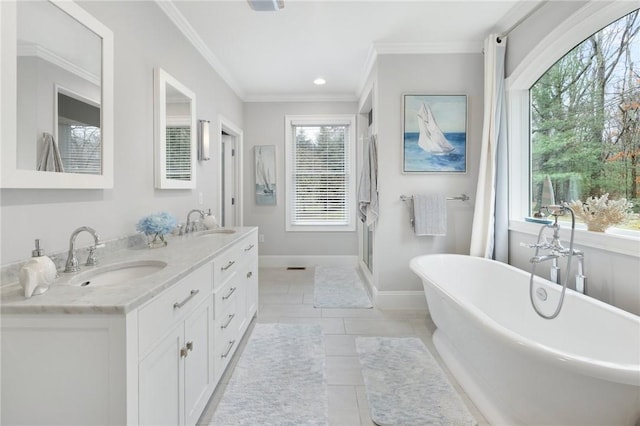 bathroom featuring tile patterned floors, vanity, crown molding, and a bath