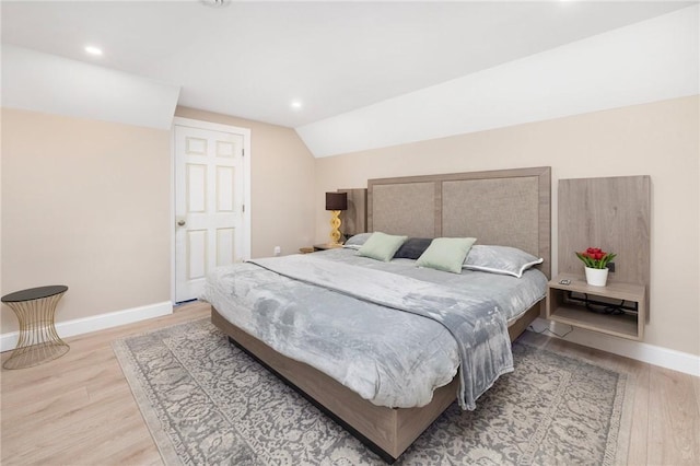 bedroom with light hardwood / wood-style floors and lofted ceiling