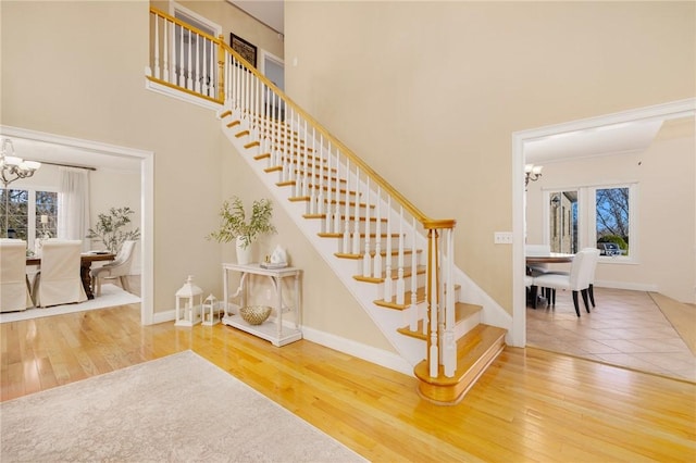 stairs featuring a notable chandelier and wood-type flooring