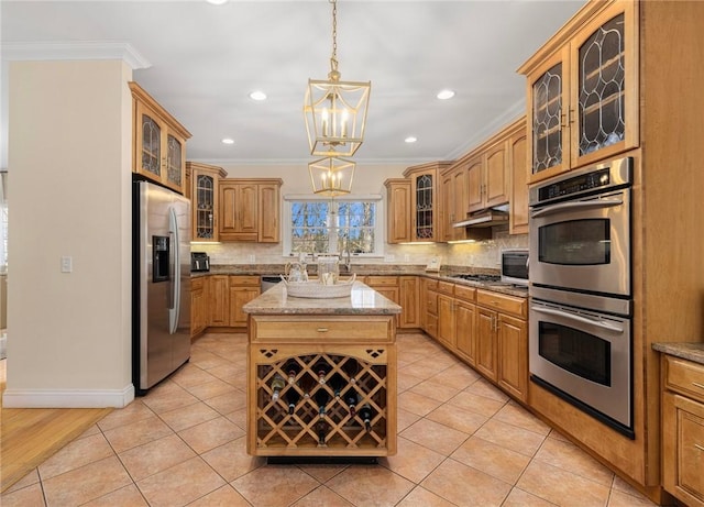 kitchen featuring a kitchen island, light stone counters, ornamental molding, and stainless steel appliances