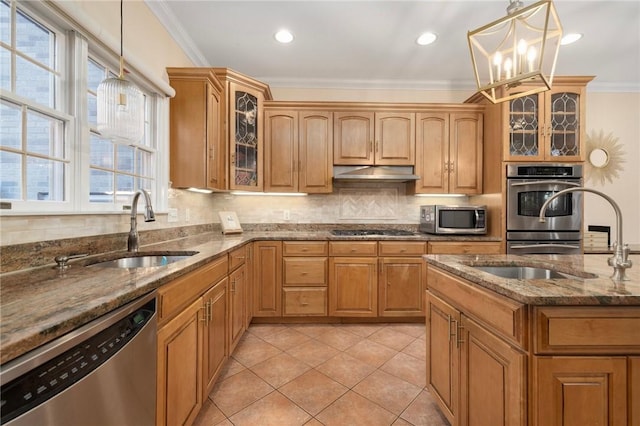 kitchen featuring sink, stainless steel appliances, a chandelier, decorative light fixtures, and stone countertops