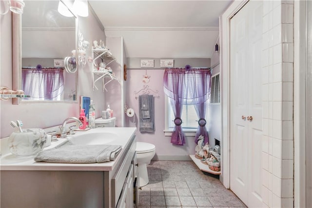 bathroom with tile patterned floors, vanity, toilet, and ornamental molding