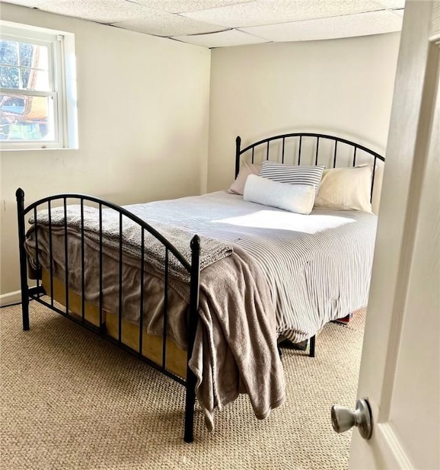 carpeted bedroom with a paneled ceiling