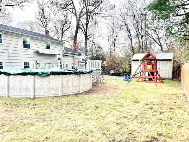 view of yard with a playground, a shed, and a covered pool