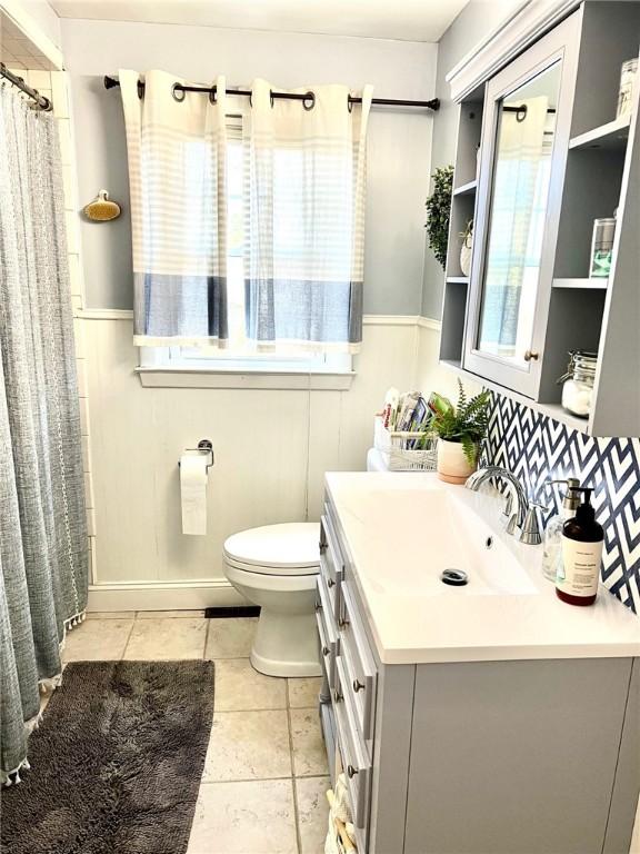 bathroom featuring tile patterned flooring, vanity, and toilet