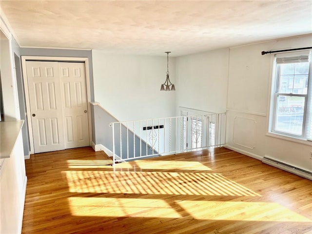 foyer with wood-type flooring and a baseboard radiator