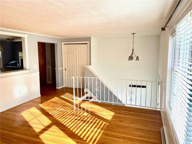 corridor featuring hardwood / wood-style floors and a baseboard radiator