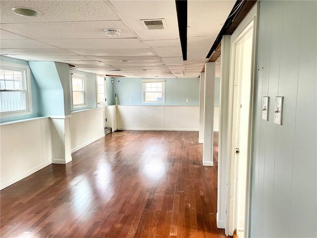 basement featuring a paneled ceiling and hardwood / wood-style flooring