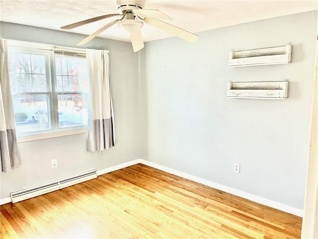 empty room featuring a wall mounted AC, a wealth of natural light, a baseboard radiator, and hardwood / wood-style flooring