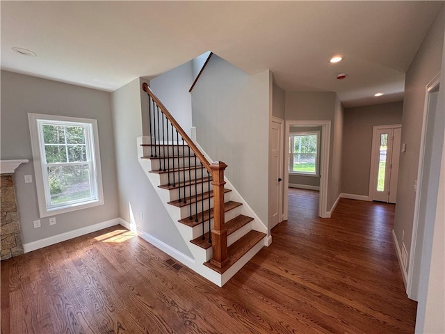 stairs with a fireplace and hardwood / wood-style floors