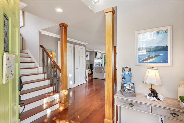 entryway with ornate columns, dark wood-type flooring, and ornamental molding