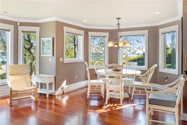 dining space featuring a chandelier, wood-type flooring, and ornamental molding