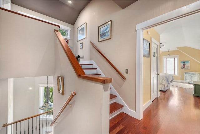 stairway with wood-type flooring and vaulted ceiling