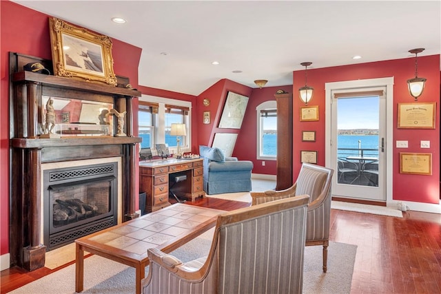 living room with hardwood / wood-style flooring and a water view