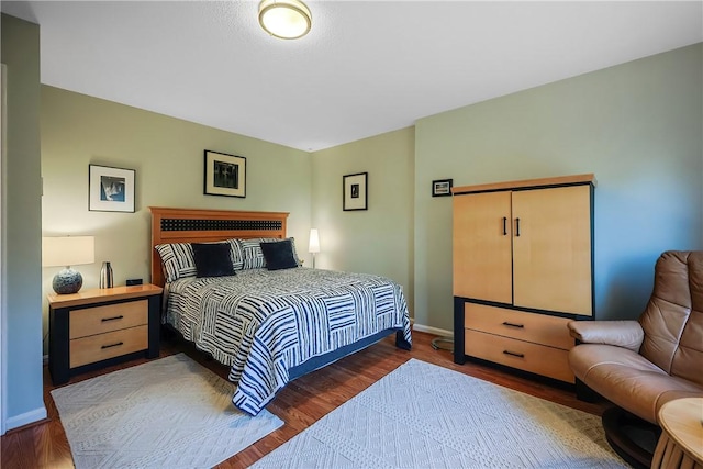 bedroom with dark hardwood / wood-style floors and a closet