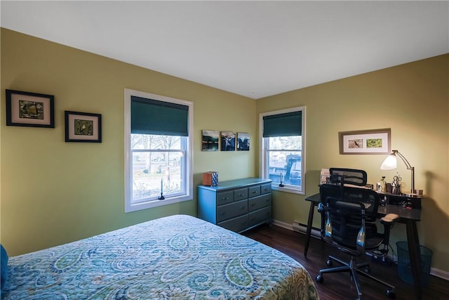 bedroom with multiple windows and dark hardwood / wood-style floors