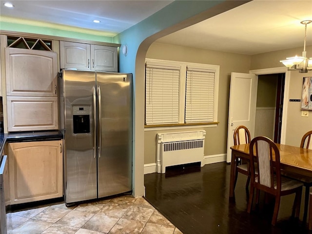 kitchen featuring a chandelier, stainless steel fridge, radiator, and hanging light fixtures