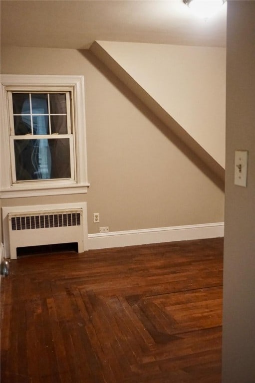 bonus room with radiator and dark hardwood / wood-style floors