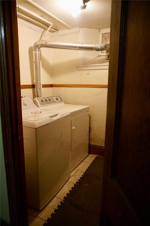 laundry room featuring washer and clothes dryer and light tile patterned floors