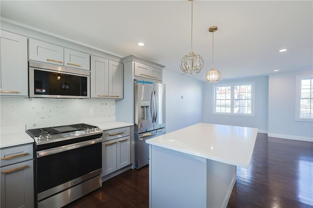 kitchen with decorative backsplash, appliances with stainless steel finishes, a chandelier, gray cabinets, and dark hardwood / wood-style floors